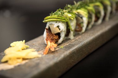 Suşi karides ile taş bir plaka üzerinde rulo.