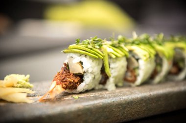 Suşi karides ile taş bir plaka üzerinde rulo.