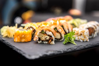 siyah bir tabağa suşi rulo