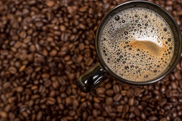 Sfondo chicchi di caffè e tazza nera con bevanda calda — Foto Stock