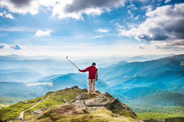 Jongeman op berg selfie te nemen — Stockfoto