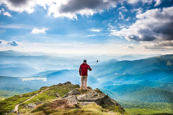 Ung man på berget tar selfie — Stockfoto