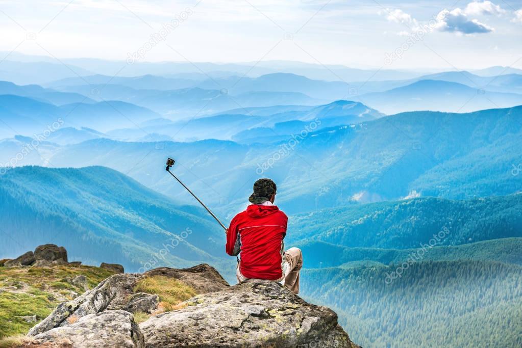 Young man on mountain taking selfie