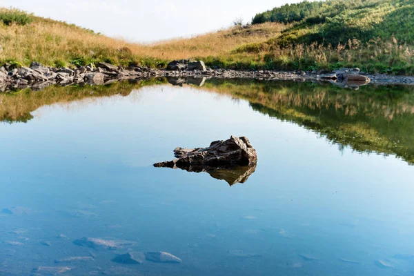 Камни в голубой воде горного озера — стоковое фото