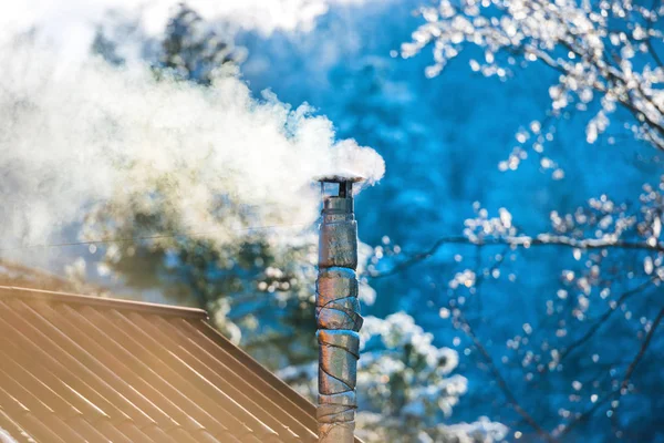 Дым из дымохода на крыше — стоковое фото