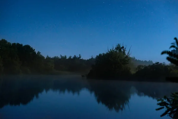 Ночь на озере с темной водой — стоковое фото