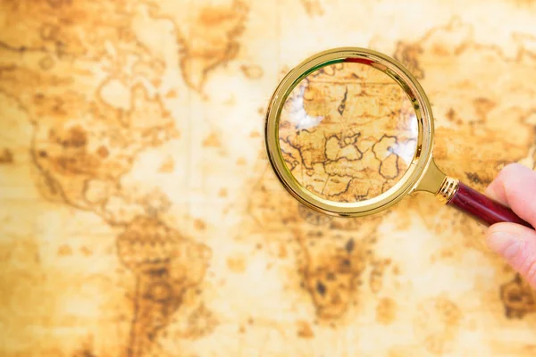 Old map and magnifying glass in a hand — Stock Photo, Image