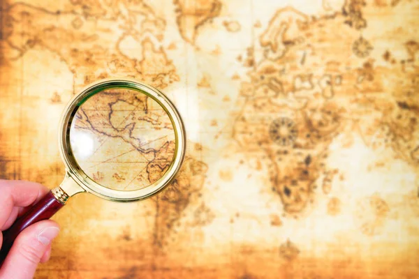 Old map and magnifying glass in a hand — Stock Photo, Image