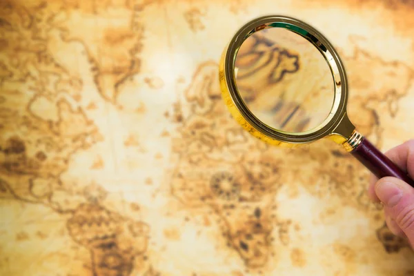 Old map and magnifying glass in a hand — Stock Photo, Image