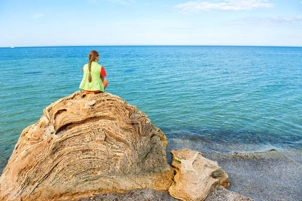 Giovane donna seduta su una grande roccia — Foto Stock