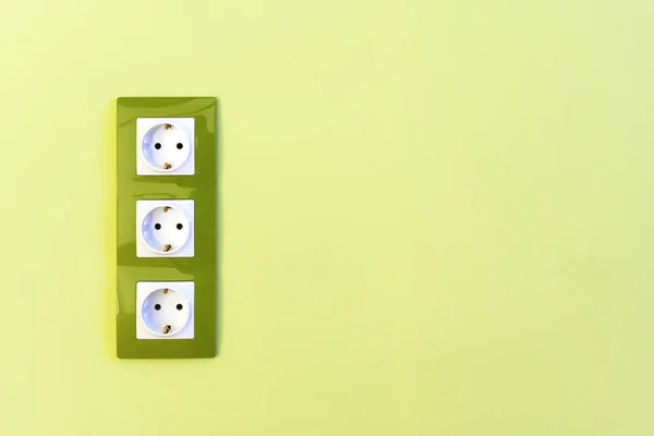 Electric sockets on green wall — Stock Photo, Image