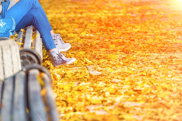 Woman sitting on bench in autumn park — Stock Photo, Image