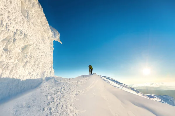 Hombre senderismo en la ladera nevada —  Fotos de Stock
