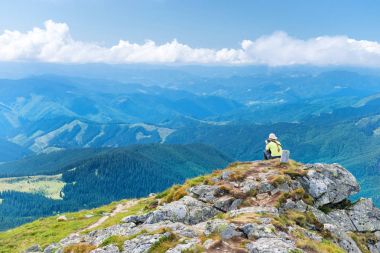 Cliff üzerinde oturan kadın