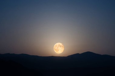 Gece gökyüzü üzerinde ay yükselen 