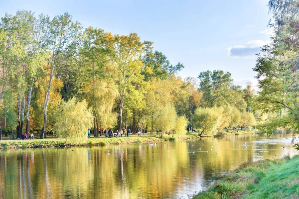 Lago no parque da cidade com pessoas ambulantes — Fotografia de Stock