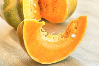 Turuncu olgun kabak ahşap masanın üzerine dilimlenmiş