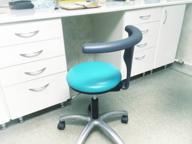 doktor ofisinde tablo yakınındaki mavi sandalye