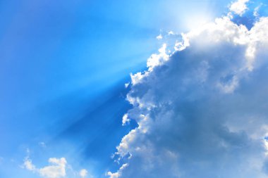 Beautiful blue sky with sunbeams and clouds. Sun rays showing shades of blue. clipart