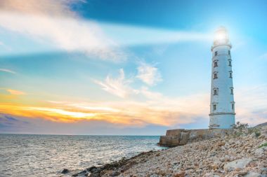 Deniz feneri projektör ışını deniz havası gün batımında