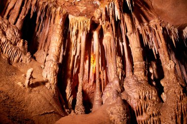Cave dark interior with light, stalactites and stalagmites clipart