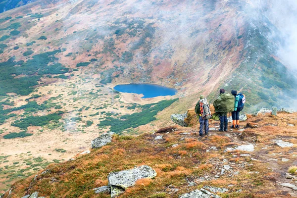 Grupo Excursionistas Amigos Las Montañas Mirando Paisaje Con Lago Azul —  Fotos de Stock