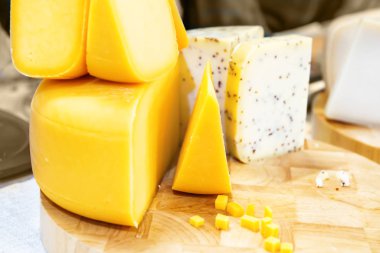 Tahta masanın üzerinde çeşitli peynir çeşitleri var.