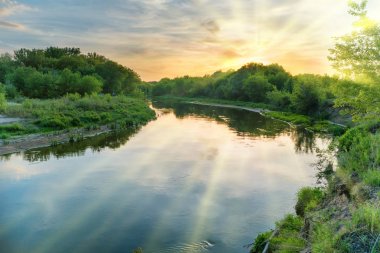 Manzara ile yeşil ağaçlar, dramatik gökyüzü, bulutlar günbatımı arka plan üzerinde