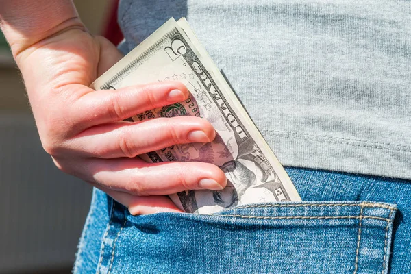 Mano Femminile Mettendo Soldi Dollari Tasca Jeans — Foto Stock