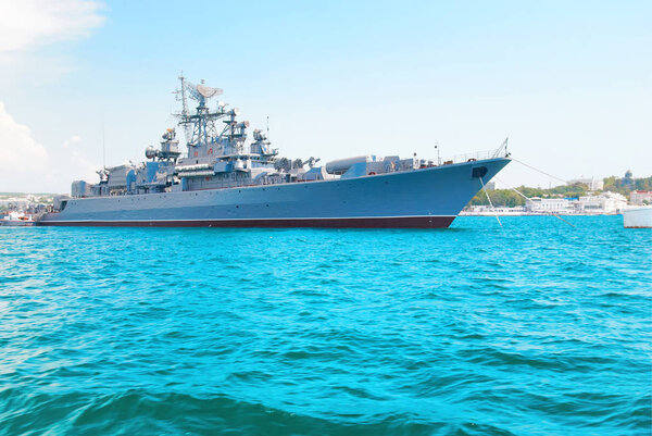 Military navy ship in blue sea with sky and clouds