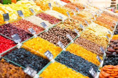 Kuru üzüm yığını, farklı türde fındık ve tezgahta diğer organik yiyecekler.