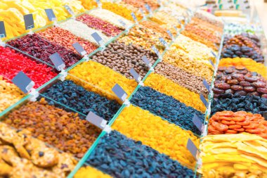 Kuru üzüm yığını, farklı türde fındık ve tezgahta diğer organik yiyecekler.