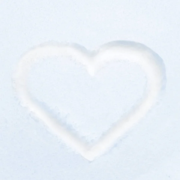 Blue heart shape drawing on white snow as love valentine background