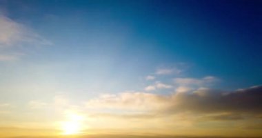 Dramatik gökyüzü ve renkli kabarık bulutlarla güzel dramatik günbatımının zamanı. 4K zaman aşımı klibi