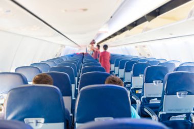 Coronavirüs pandemisi sırasında az sayıda insan ve hostesle dolu boş bir uçak.