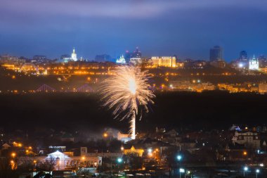 Mavi gece gökyüzünün olduğu bir şehirde bayram havai fişekleri