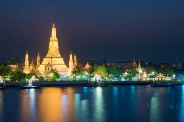 Gece, Şafak Tapınağı 'nı ya da Wat Arun' u ve günbatımında Chao Phraya Nehri 'ndeki yansımasını aydınlattı. Bangkok, Tayland