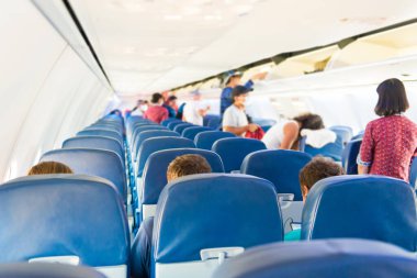 Coronavirüs pandemisi sırasında az sayıda insan ve hostesle dolu boş bir uçak.