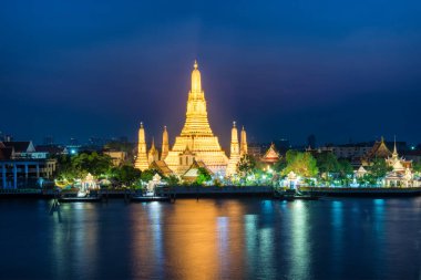 Gece, Şafak Tapınağı 'nı ya da Wat Arun' u ve günbatımında Chao Phraya Nehri 'ndeki yansımasını aydınlattı. Bangkok, Tayland