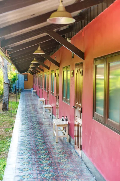 亚洲酒店设有红墙 瓷砖地板 一排窗户和木门的空旷长廊 — 图库照片