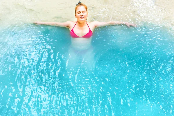 赤髪の美しい若い女性は青い水の湖で泳ぐリラックス — ストック写真
