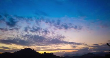 Dramatik gökyüzü ve renkli bulutlarla dağların üzerinde güzel bir gündoğumu zamanı. 4K zaman aşımı klibi
