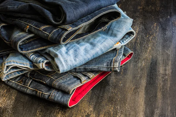 Jeans stacked on a wooden chair — Stock Photo, Image