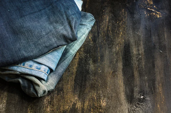 Jeans stacked on a wooden chair — Stock Photo, Image