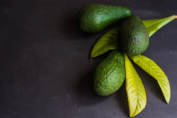 Avokado frukter på mörka bord — Stockfoto