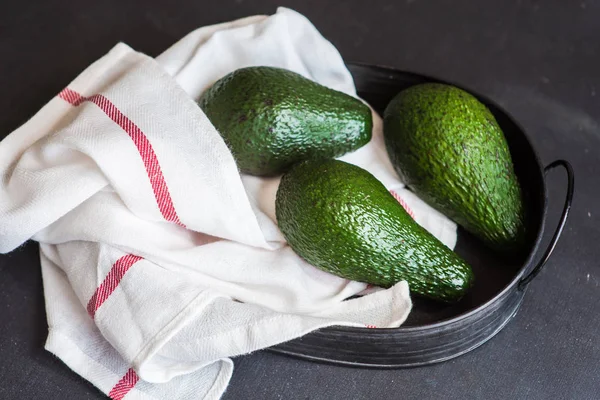 Avokado frukter på mörka bord — Stockfoto