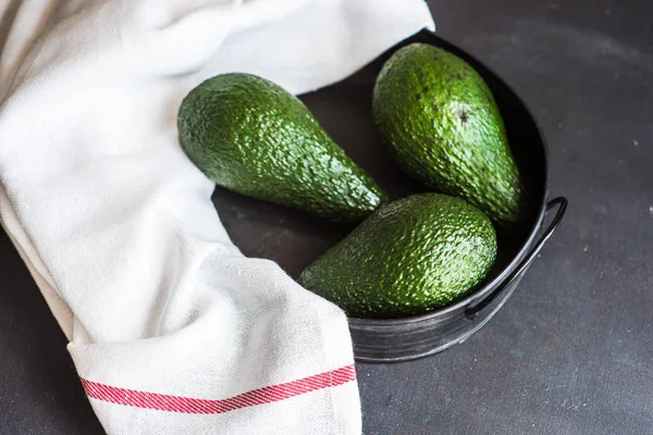 Плоды авокадо на тёмном столе — стоковое фото