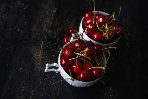 Sweet cherries on dark wooden table — Stock Photo, Image