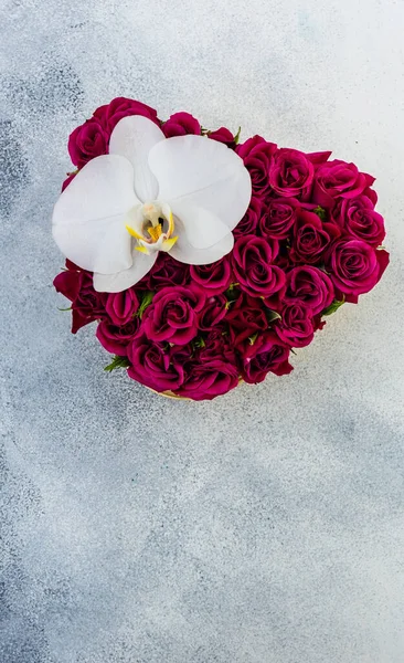 コピースペース付きの石の背景に赤いバラでいっぱいのバレンタインデーハート型の箱のギフトコンセプト — ストック写真