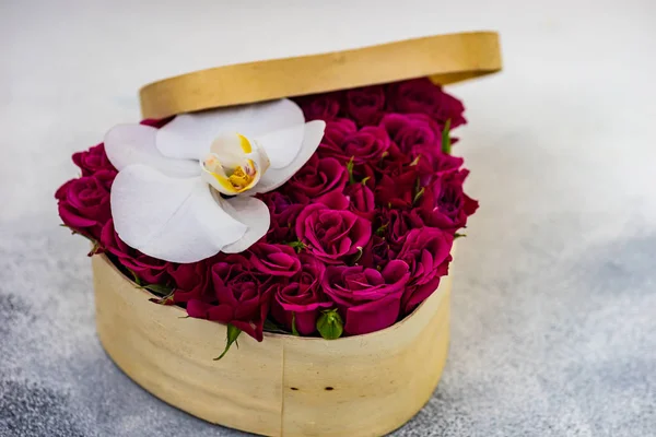 コピースペース付きの石の背景に赤いバラでいっぱいのバレンタインデーハート型の箱のギフトコンセプト — ストック写真